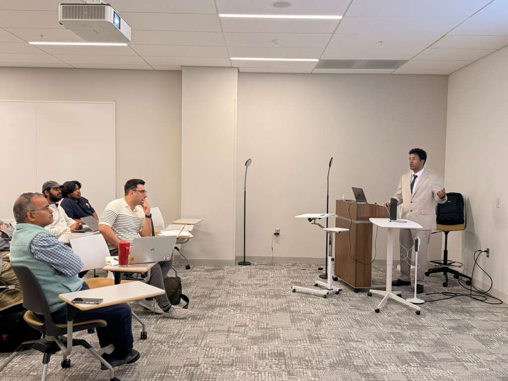 Vishal Pallagani presenting his dissertation defense in a classroom on March 26, 2026.